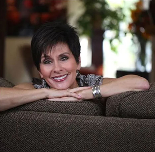 Smiling woman on couch, cosmetic dentistry, dental implants, porcelain veneers, South Metro Atlanta dentist.